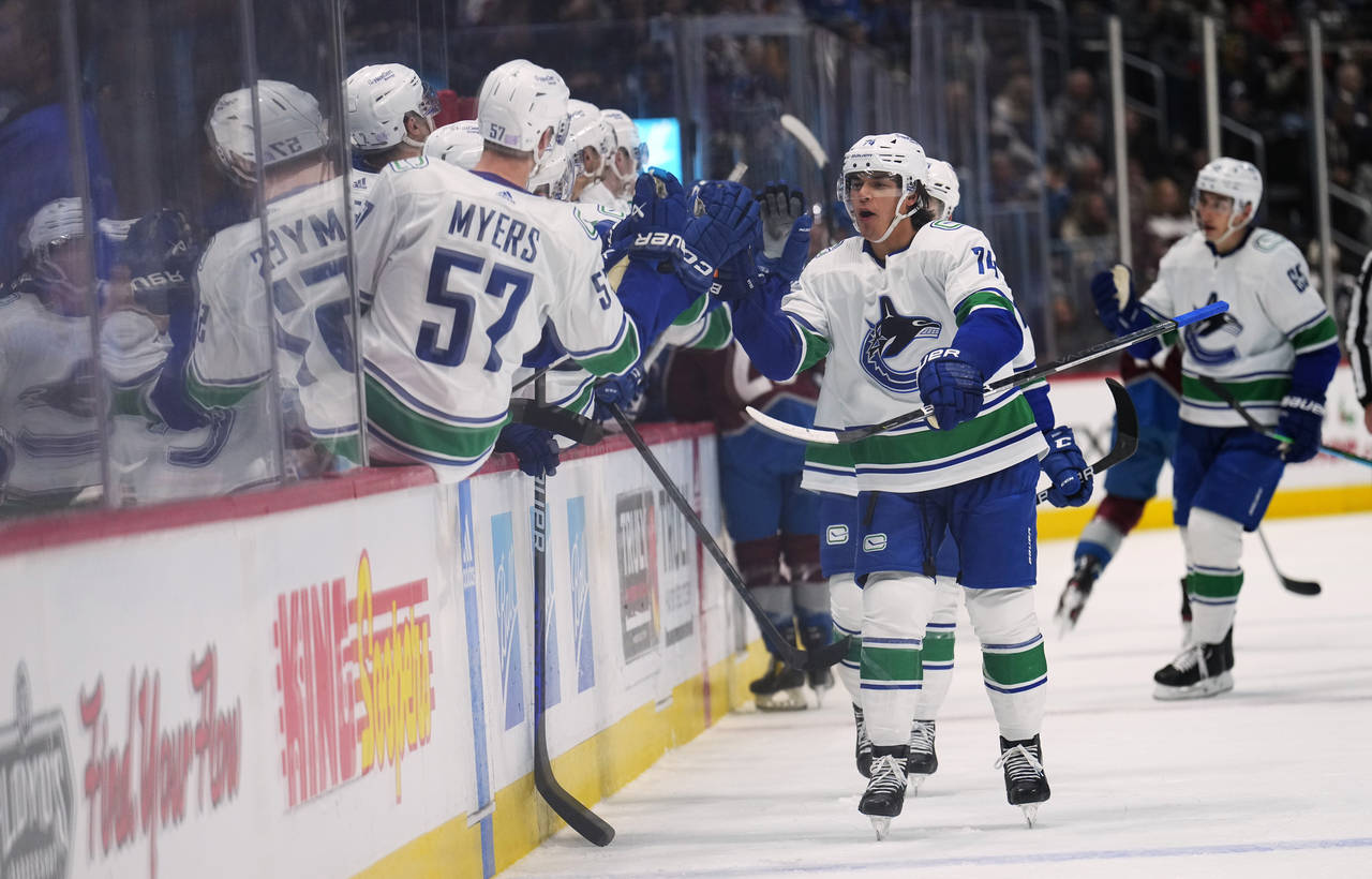 Vancouver Canucks defenseman Ethan Bear (74) is congratulated for his goal against the Colorado Ava...
