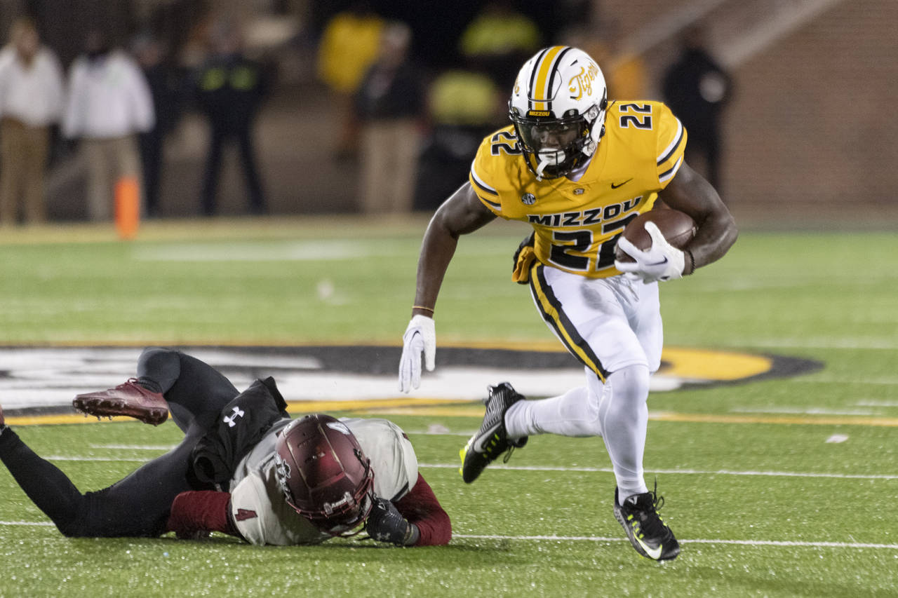 Missouri running back Tavorus Jones, right, runs pasts New Mexico State defensive back BJ Sculark d...