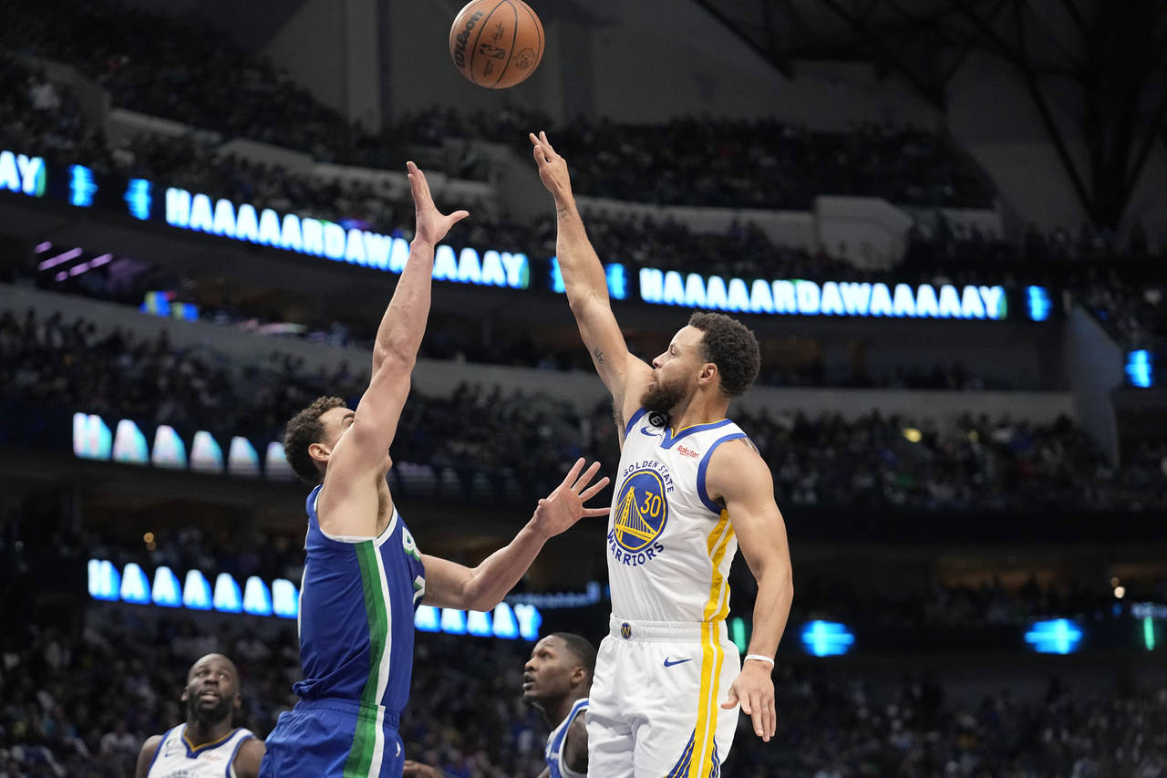 Golden State Warriors guard Stephen Curry (30) takes a shot over Dallas Mavericks center Dwight Pow...
