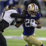 
              Washington running back Cameron Davis tries to get past Colorado defensive back Kaylin Moore during the first half of an NCAA college football game Saturday, Nov. 19, 2022, in Seattle. (AP Photo/Stephen Brashear)
            