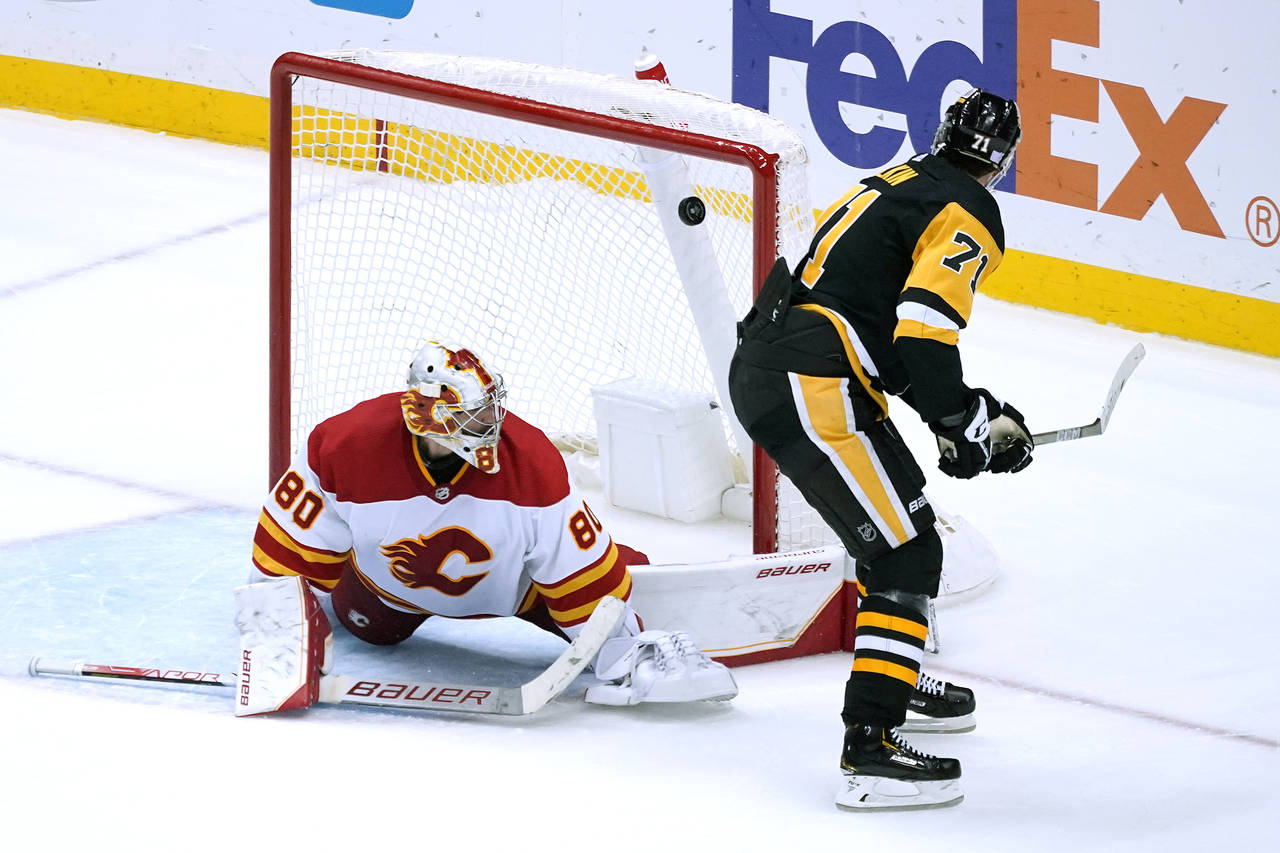 Pittsburgh Penguins' Evgeni Malkin (71) gets a backhand shot past Calgary Flames goaltender Dan Vla...