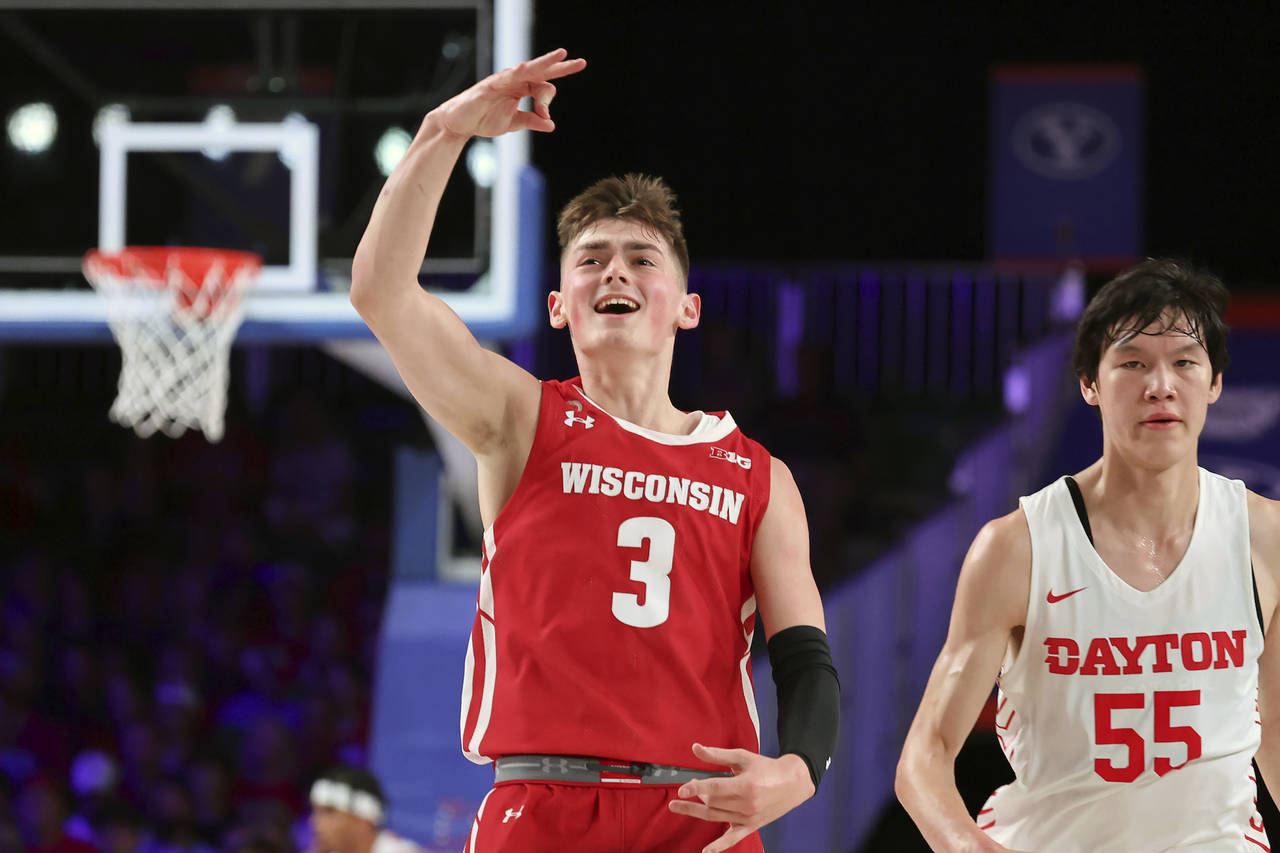 This photo provided by Bahamas Visual Services shows Wisconsin guard Connor Essegian reacting next ...