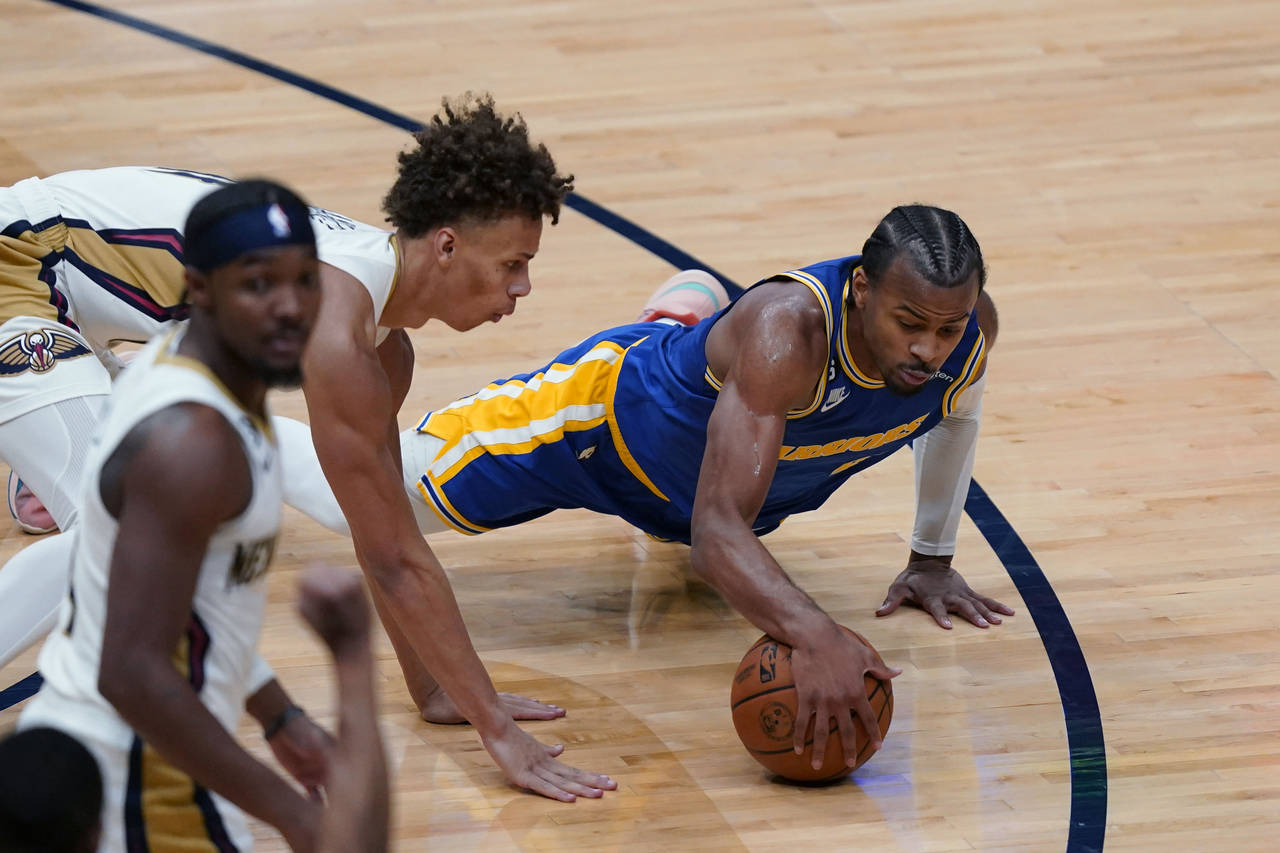 Golden State Warriors guard Ryan Rollins dives for the ball against New Orleans Pelicans guard Dyso...
