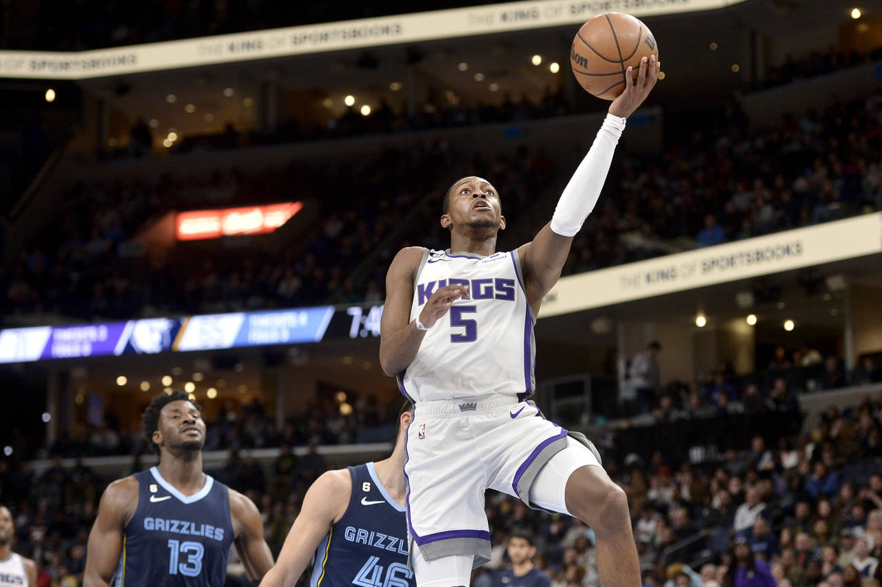 Sacramento Kings guard De'Aaron Fox (5) shoots the ball ahead of Memphis Grizzlies guard John Konch...