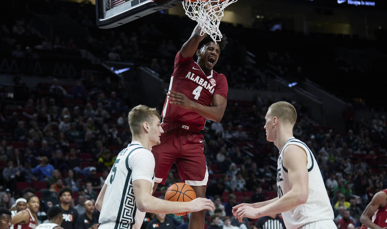 Alabama forward Noah Gurley (4) dunks over Michigan State guard Tre Holloman, left, and forward Joe...