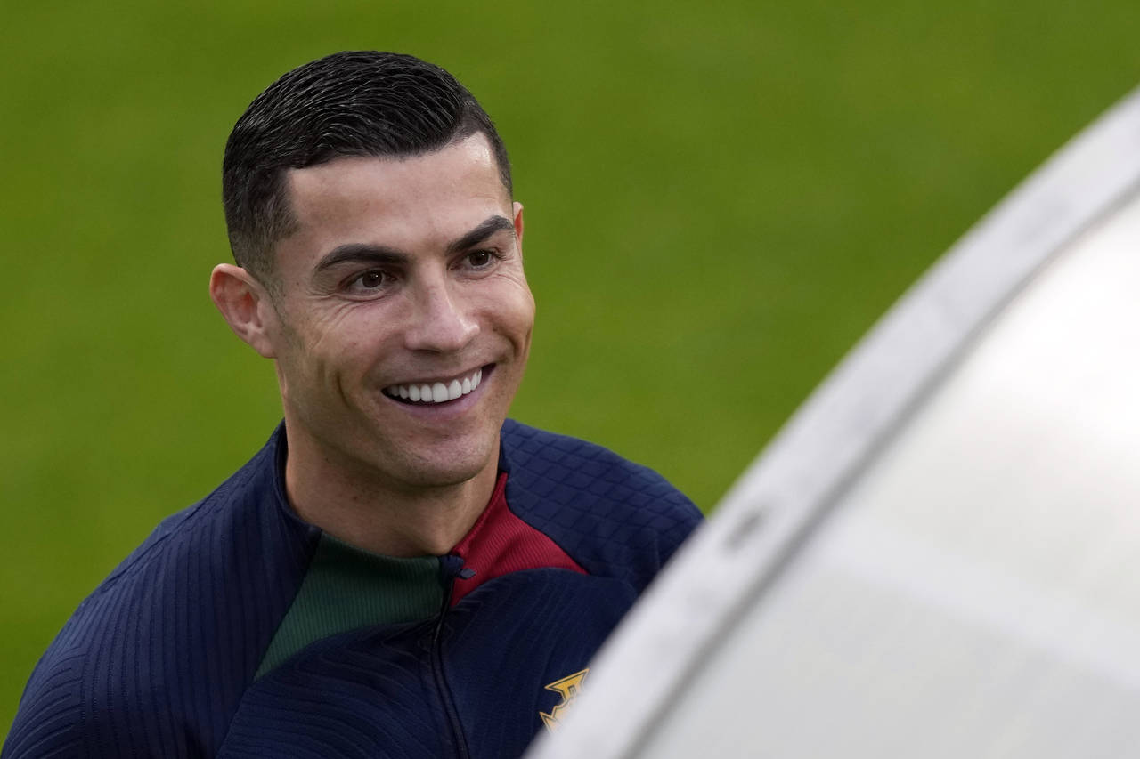 Cristiano Ronaldo smiles as he arrives for a Portugal soccer team training session in Oeiras, outsi...