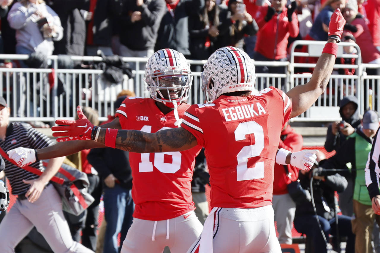 Ohio State receiver Marvin Harrison, left, celebrates his touchdown against Michigan with teammate ...