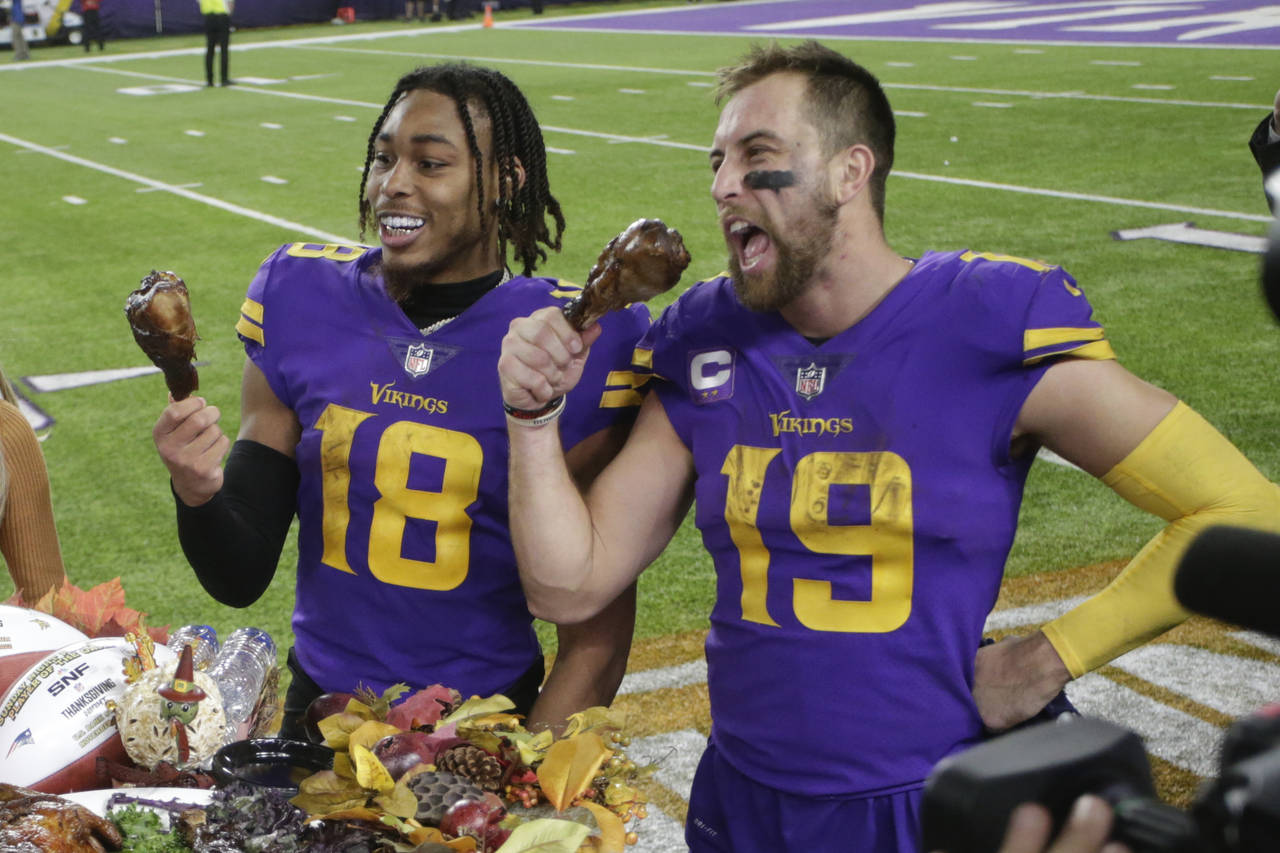 Minnesota Vikings wide receiver Justin Jefferson (18) and wide receiver Adam Thielen (19) eat turke...
