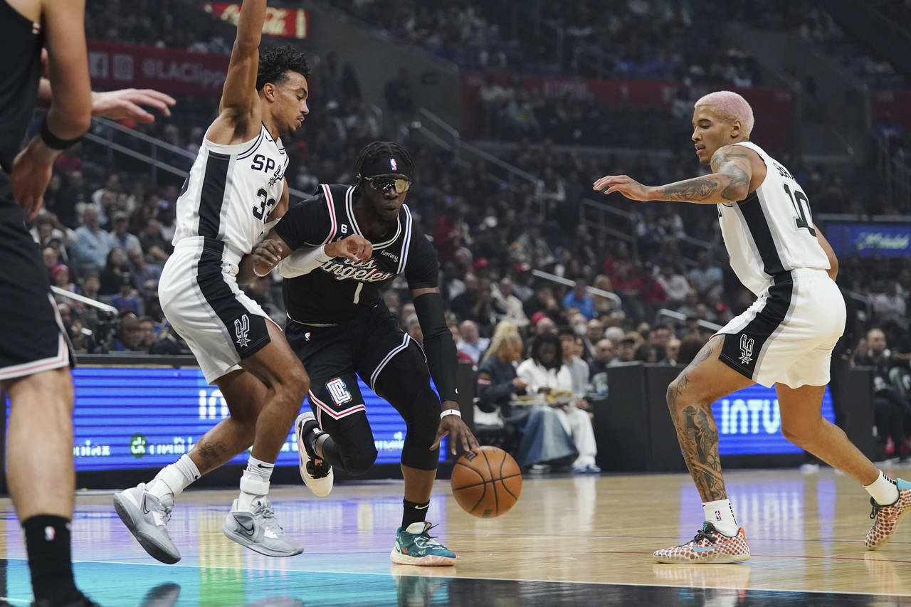 Los Angeles Clippers guard Reggie Jackson (1) dribble the ball between San Antonio Spurs guard Tre ...