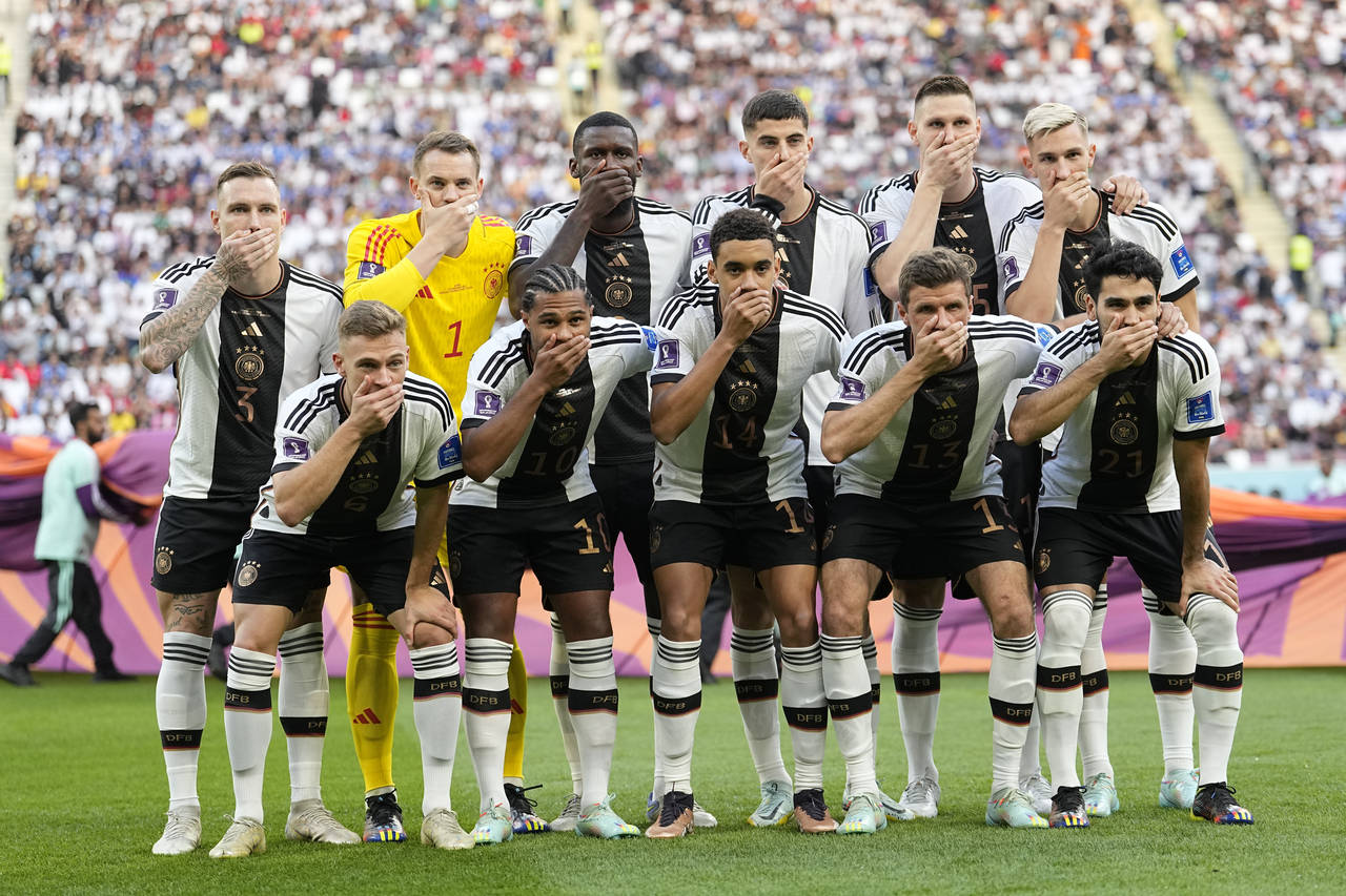 Players from Germany pose for the team photo as they cover their mouth during the World Cup group E...