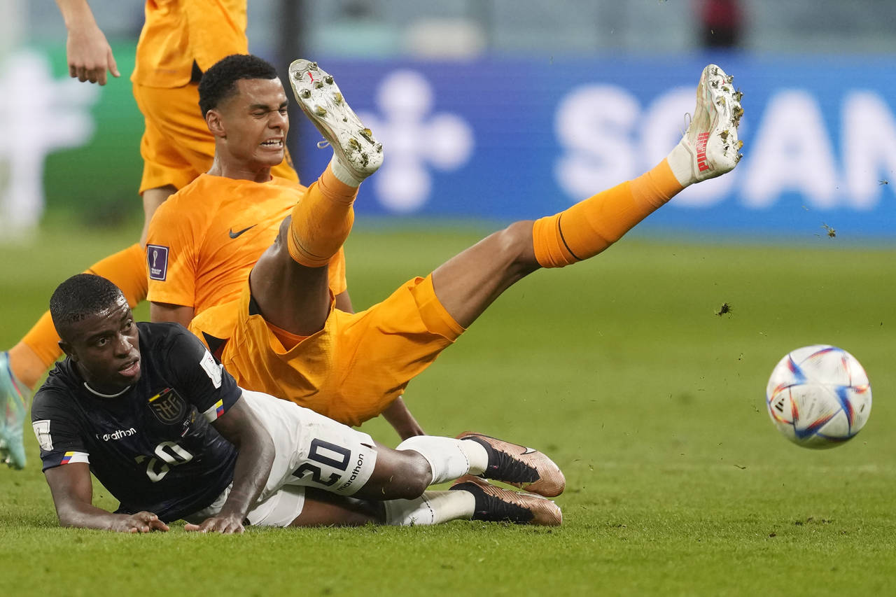 Cody Gakpo of the Netherlands, centre, and Ecuador's Jhegson Mendez, bottom, challenge for the ball...