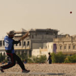 Laborers play sandlot cricket near World Cup soccer stadiums