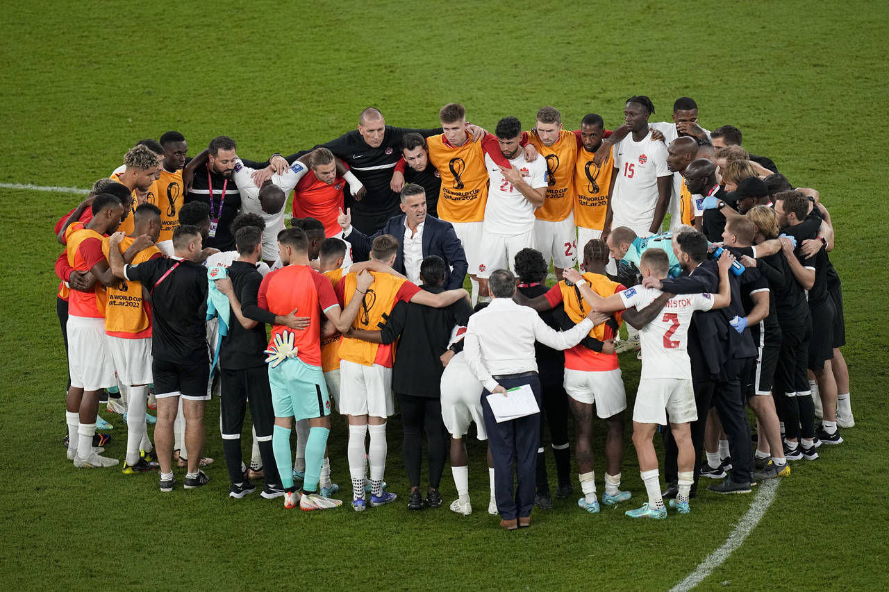 Canada's head coach John Herdman talks with his team after their loss in the World Cup group F socc...