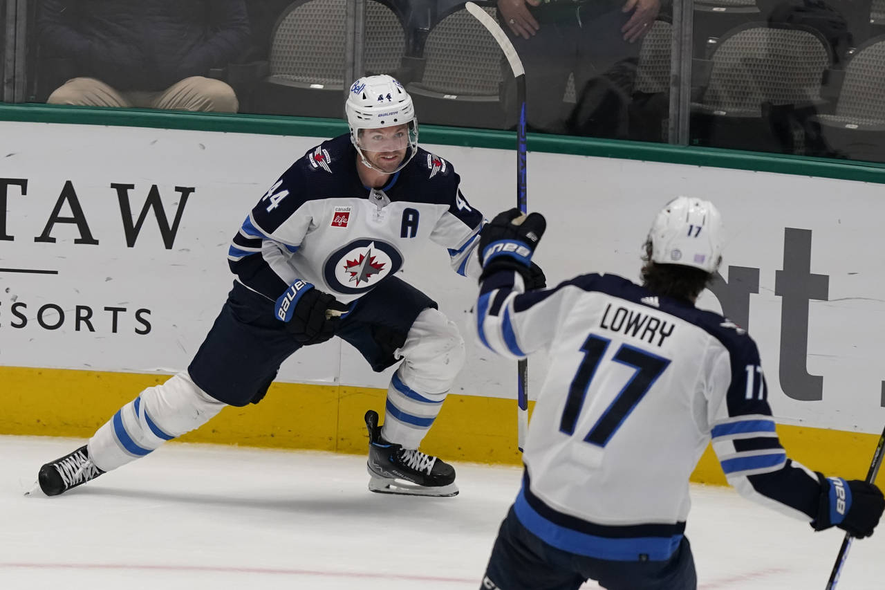 Winnipeg Jets' Josh Morrissey (44) celebrates scoring a goal with teammate Adam Lowry (17) during o...