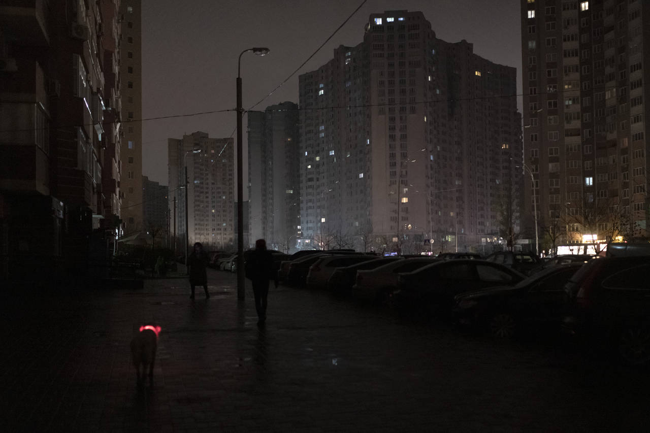 A dog with a lighted collar walks in a street during a blackout in Kyiv, Ukraine, Wednesday, Nov. 1...