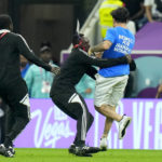 Spectator with rainbow flag runs onto field at World Cup
