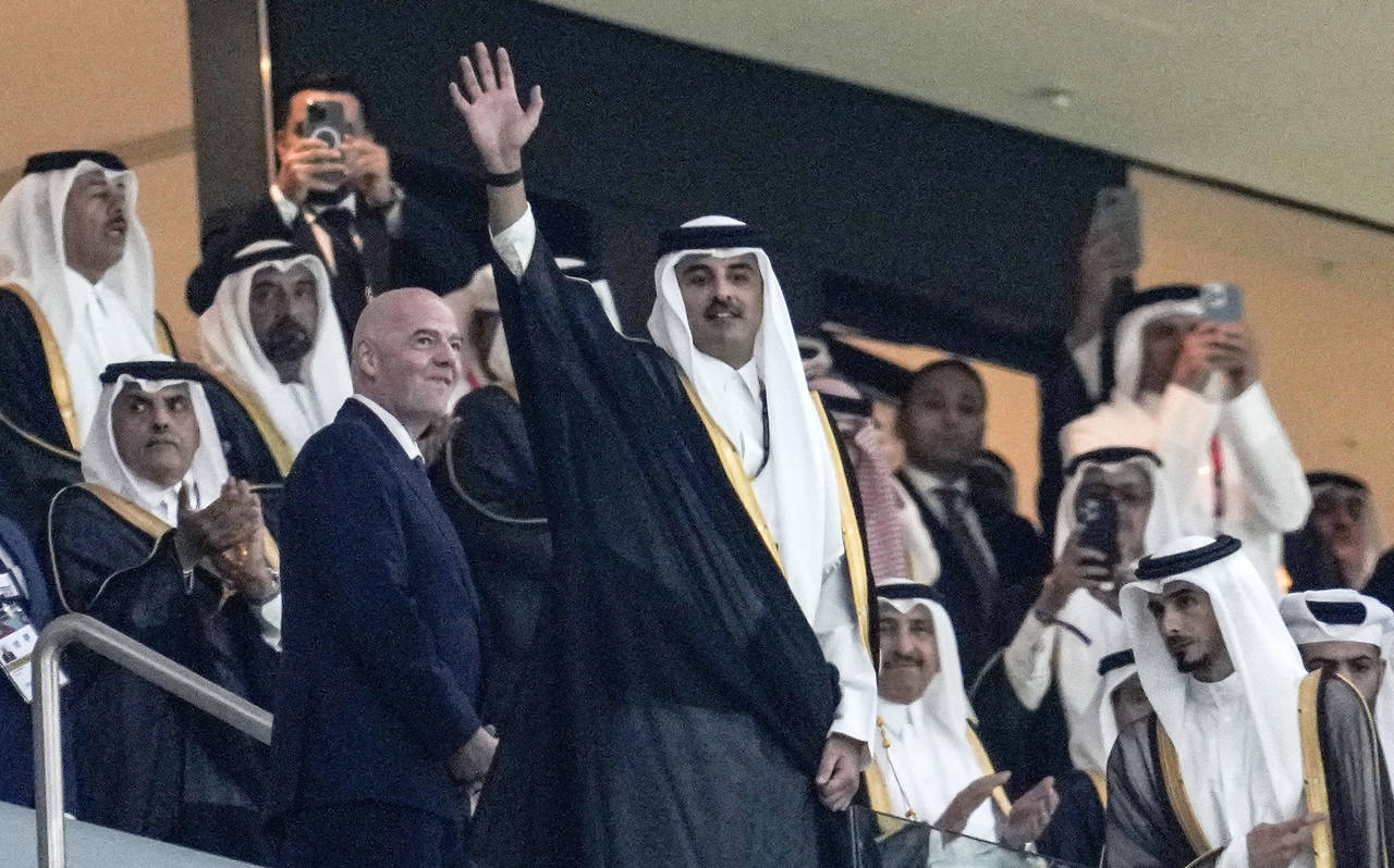 Emir of Qatar Tamim bin Hamad Al Thani waves to the crowd beside FIFA President Giovanni Infantino,...