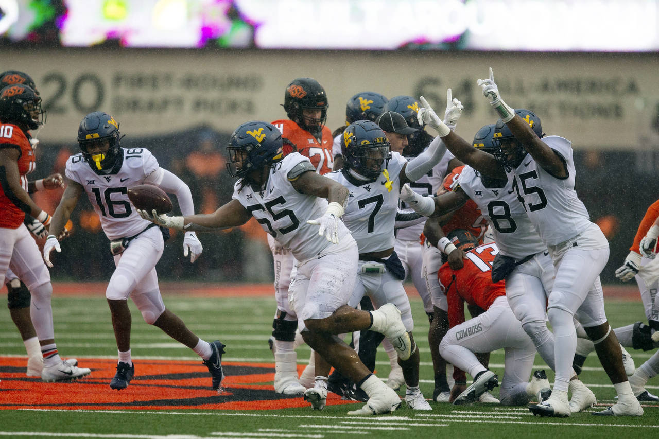 West Virginia defensive lineman Dante Stills (55) celebrates after recovering a fumble during the s...