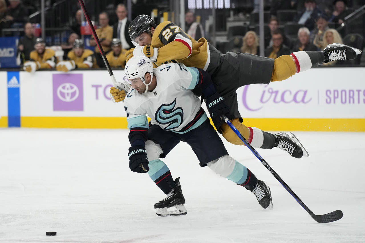 Vegas Golden Knights defenseman Shea Theodore, right, collides with Seattle Kraken right wing Jorda...