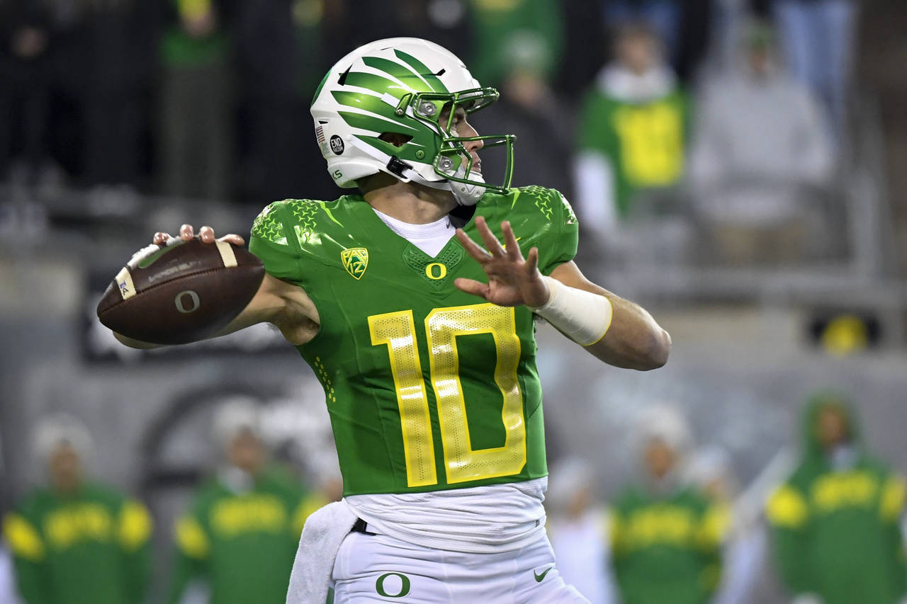 Oregon quarterback Bo Nix looks for a receiver during the first half of the team's NCAA college foo...
