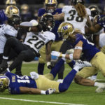 
              Colorado running back Deion Smith is stopped by Washington defensive back Asa Turner, right, linebacker Daniel Heimuli, on turf, and defensive back Zakhari Spears left, during the first half of an NCAA college football game Saturday, Nov. 19, 2022, in Seattle. (AP Photo/Stephen Brashear)
            