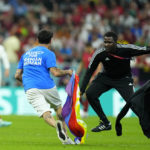 Spectator with rainbow flag runs onto field at World Cup