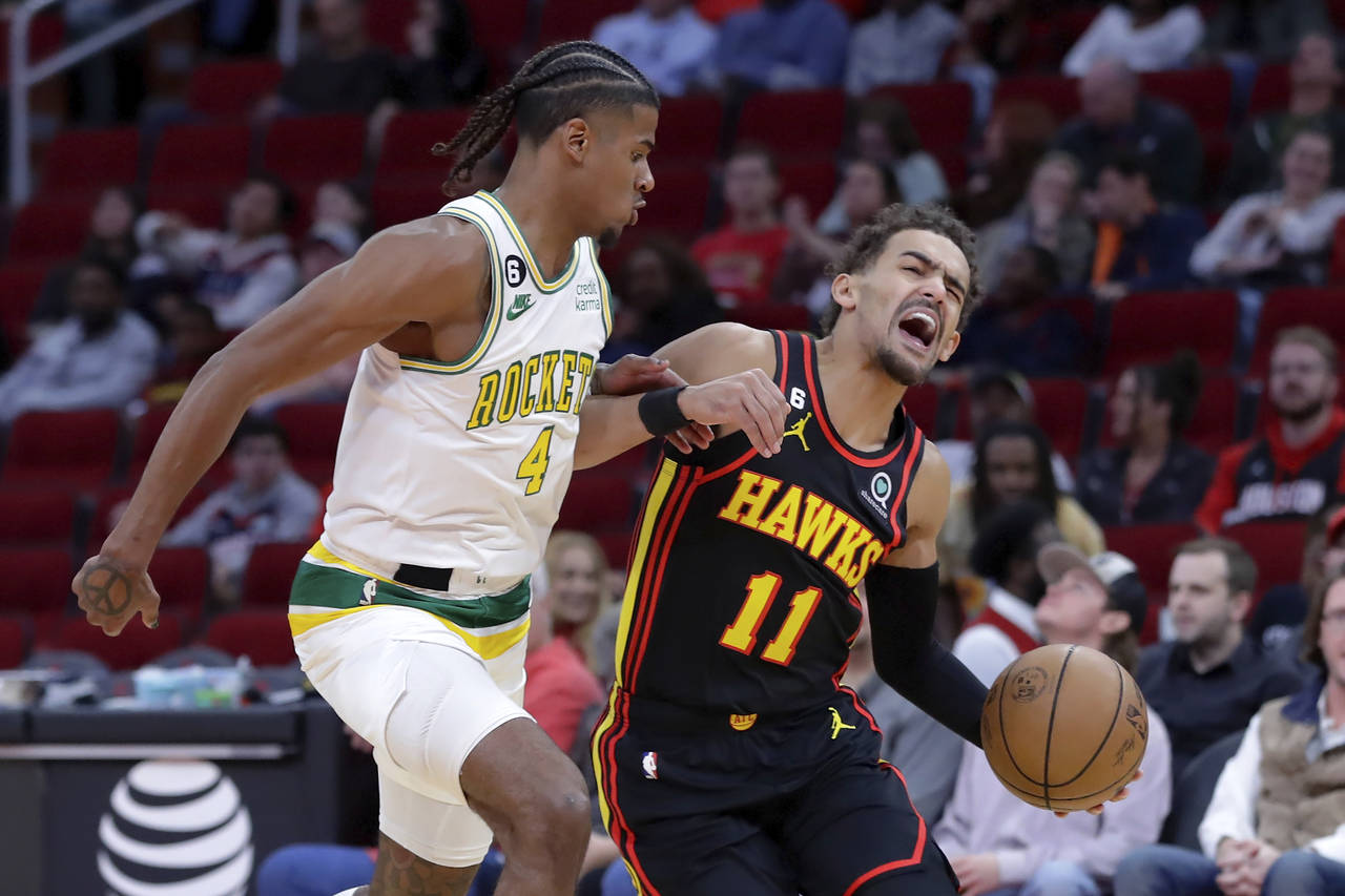 Atlanta Hawks guard Trae Young (11) reacts as he drives around Houston Rockets guard Jalen Green (4...
