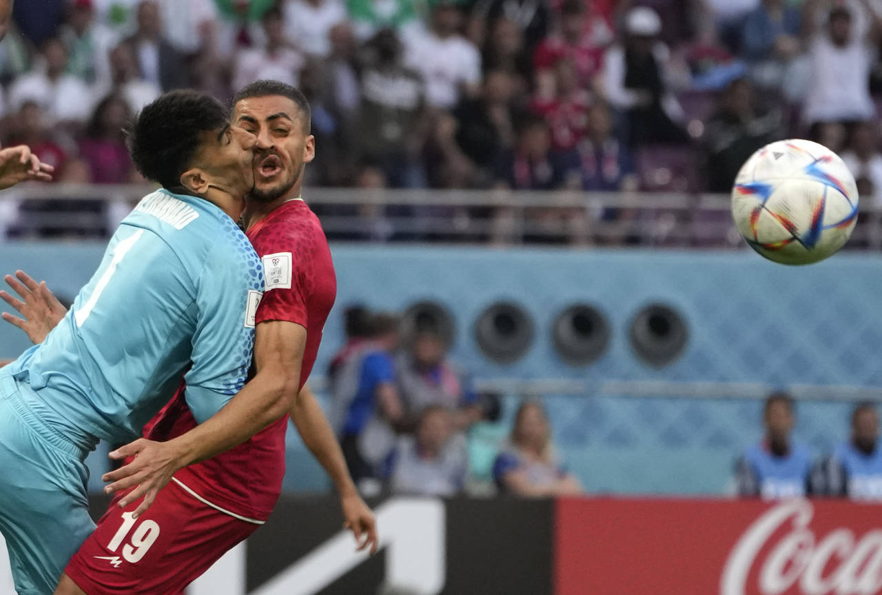 Iran's goalkeeper Alireza Beiranvand collides with Iran's Majid Hosseini, right, during the World C...