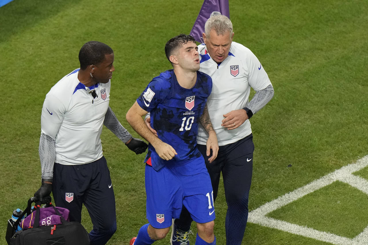 Christian Pulisic of the United States is helped by team doctors after he scoring his side's openin...