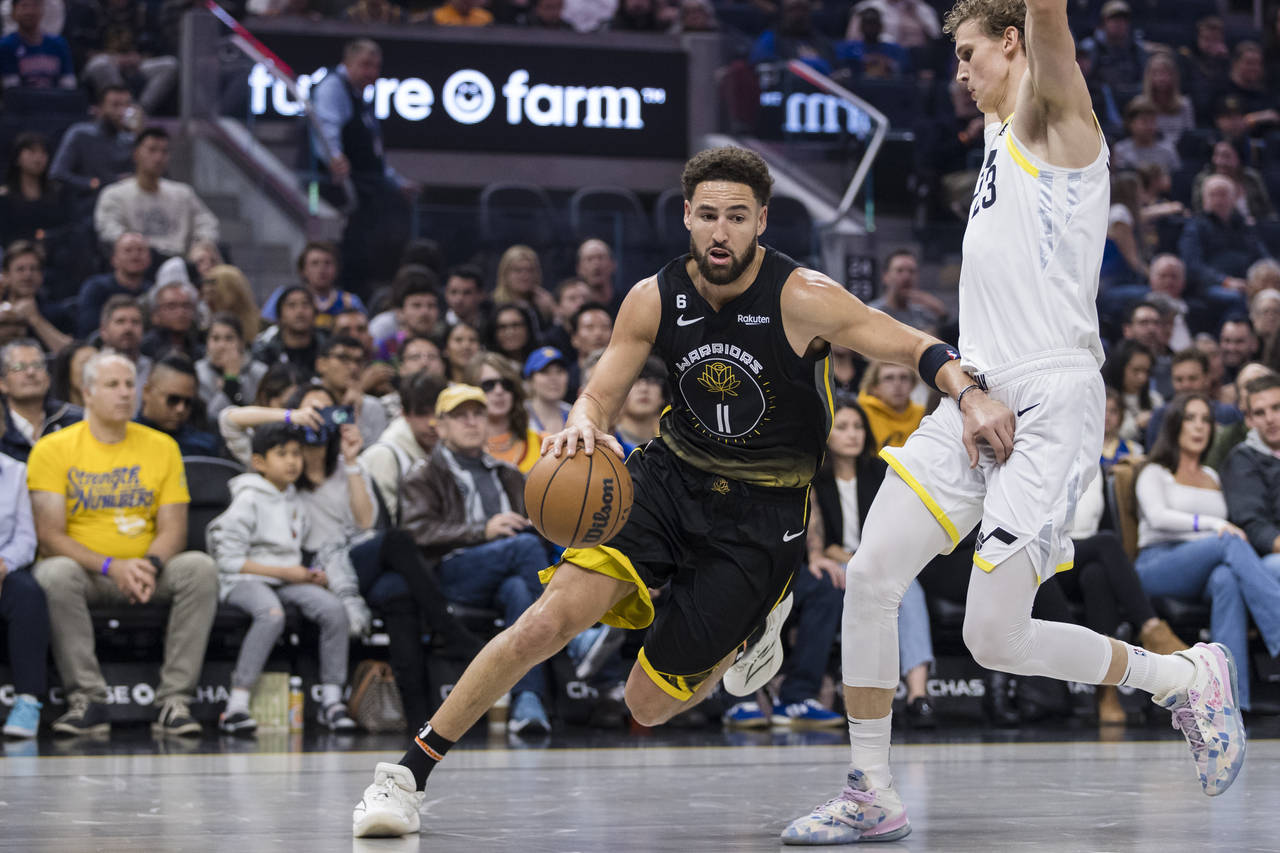 Golden State Warriors guard Klay Thompson (11) drives past Utah Jazz forward Lauri Markkanen, right...