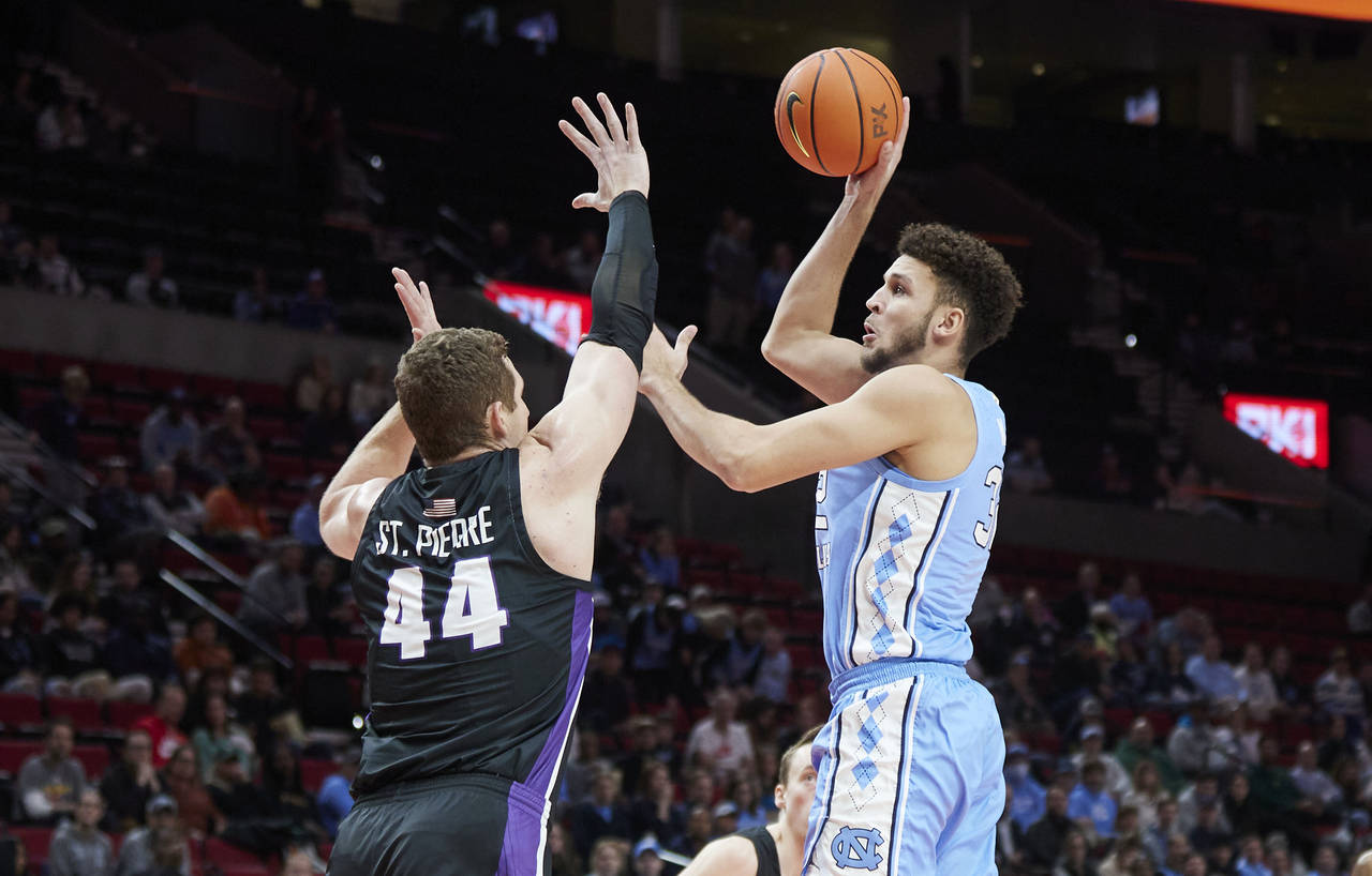 North Carolina forward Pete Nance, right, shoots over Portland center Joey St. Pierre during the fi...