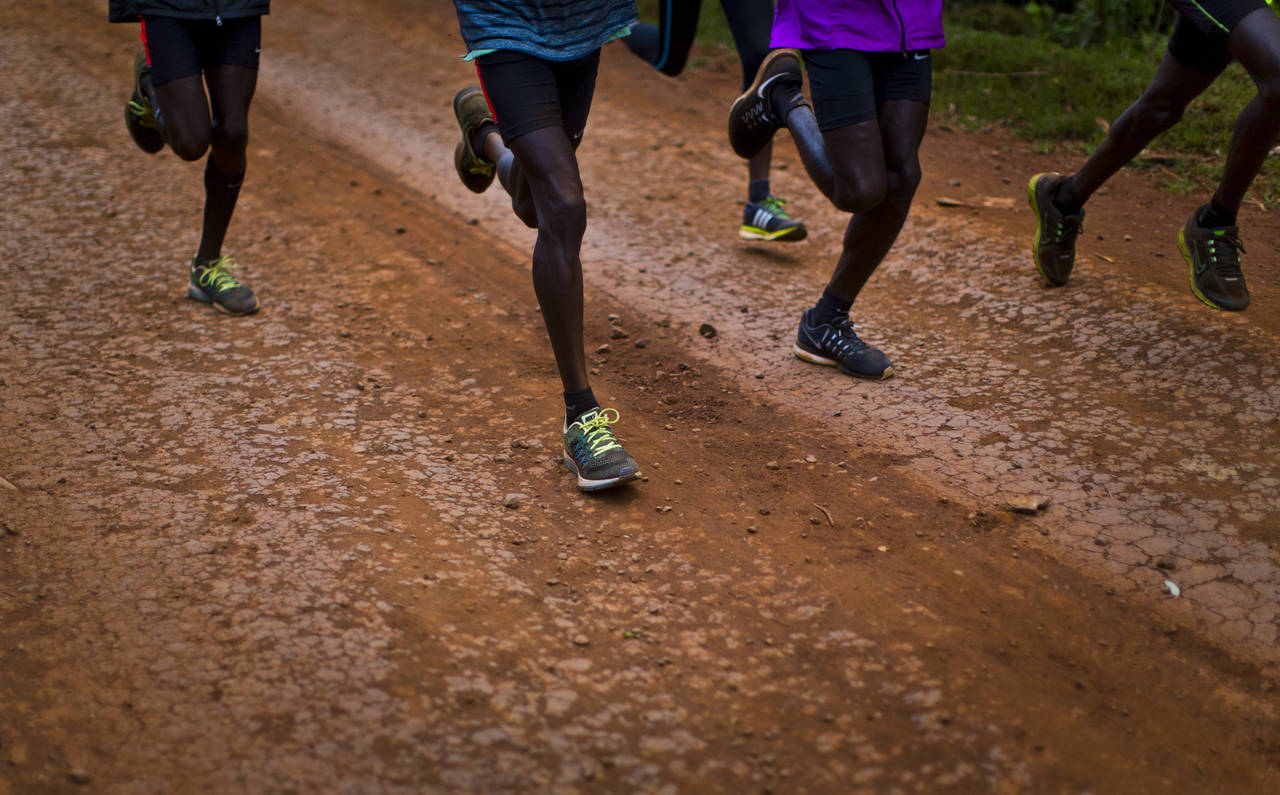 FILE - Kenyan athletes train together just after dawn on a dusty track in Kaptagat Forest in wester...