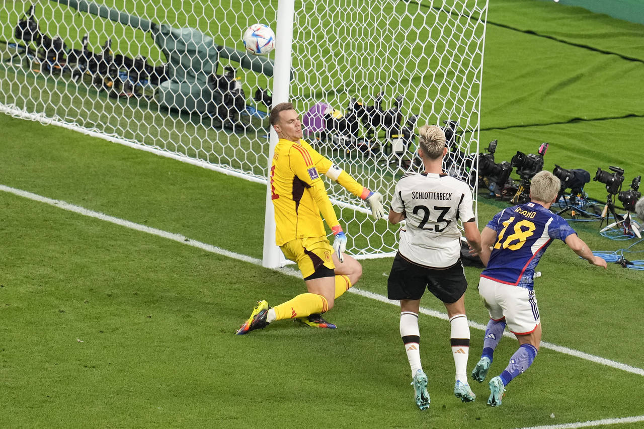Japan's Takuma Asano, right, scores is side second goal during the World Cup group E soccer match b...