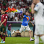 Spectator with rainbow flag runs onto field at World Cup
