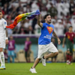 Spectator with rainbow flag runs onto field at World Cup