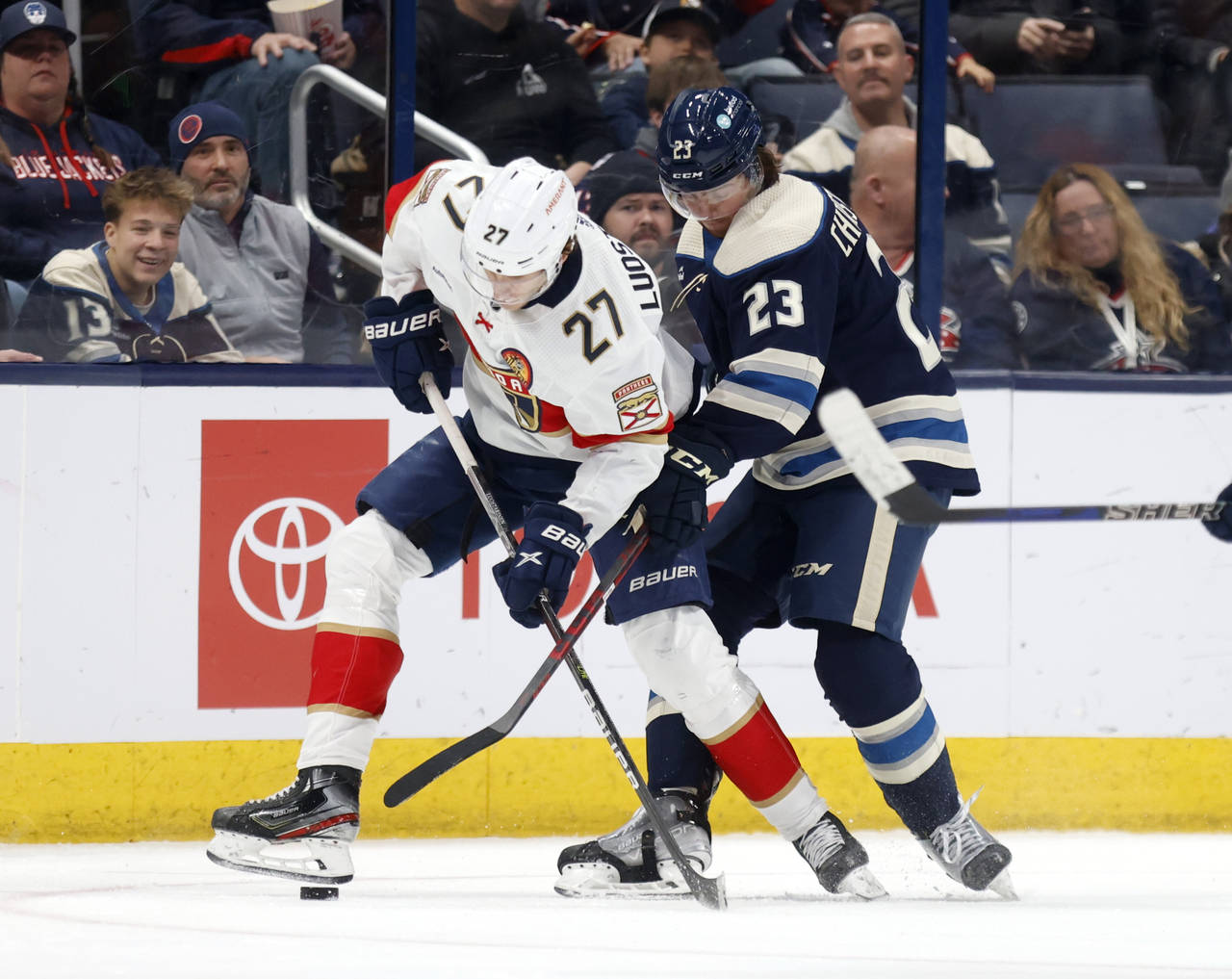 Florida Panthers forward Eetu Luostarinen, left, works for the puck in front of Columbus Blue Jacke...