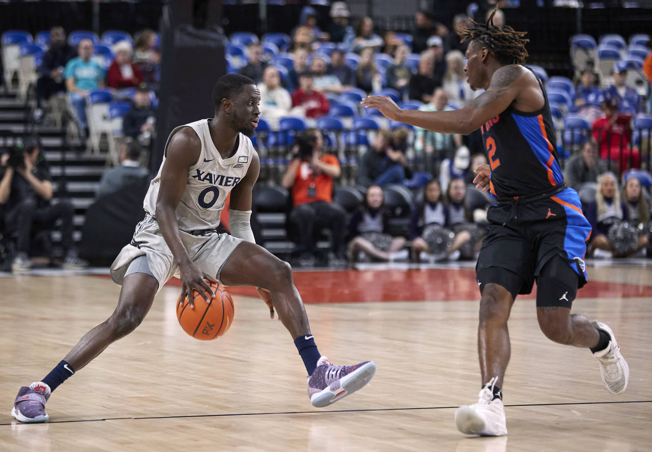 Xavier guard Souley Boum, left, is defended by Florida guard Trey Bonham during the first half of a...