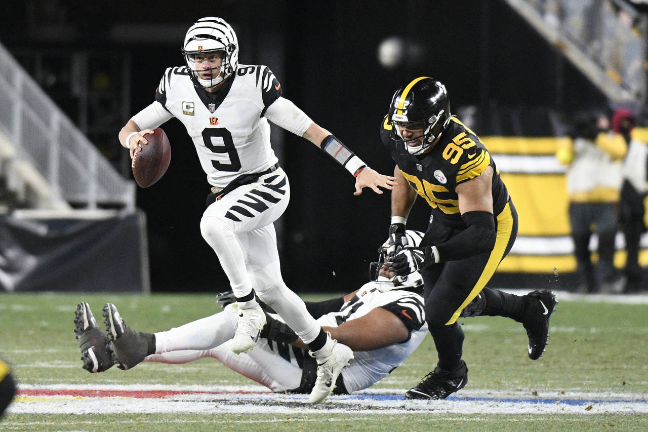 Cincinnati Bengals quarterback Joe Burrow (9) eludes Pittsburgh Steelers defensive tackle Chris Wor...