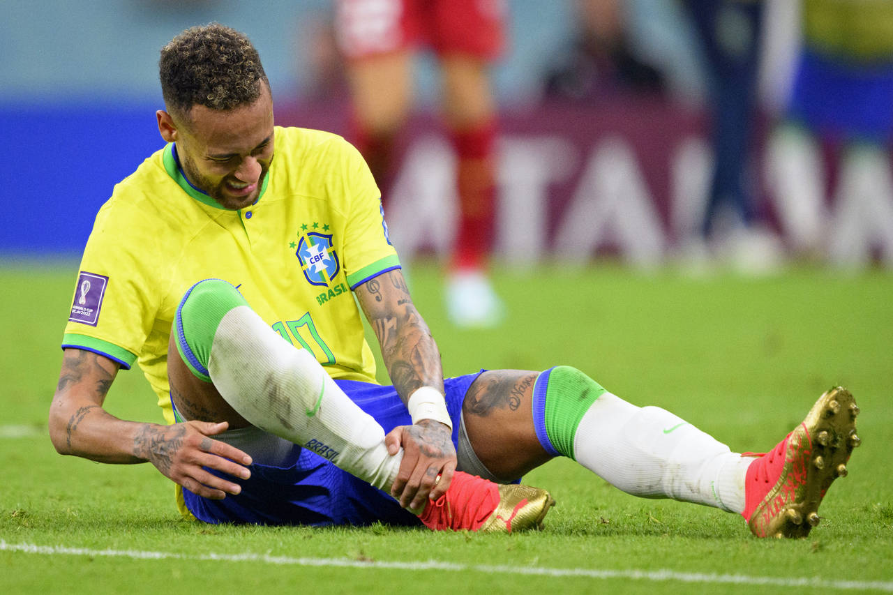Brazil's Neymar grabs his ankle after an injury during the World Cup group G soccer match between B...