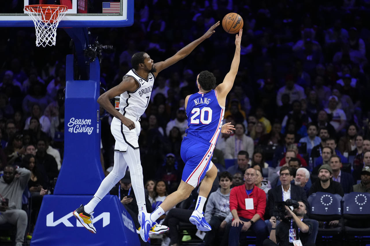 Philadelphia 76ers' Georges Niang, right, goes up for a shot against Brooklyn Nets' Kevin Durant du...
