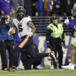
              Oregon State running back Deshaun Fenwick (5) runs for a touchdown as Washington cornerback Jordan Perryman (1) pursues during the second half of an NCAA college football game Friday, Nov. 4, 2022, in Seattle. (AP Photo/John Froschauer)
            