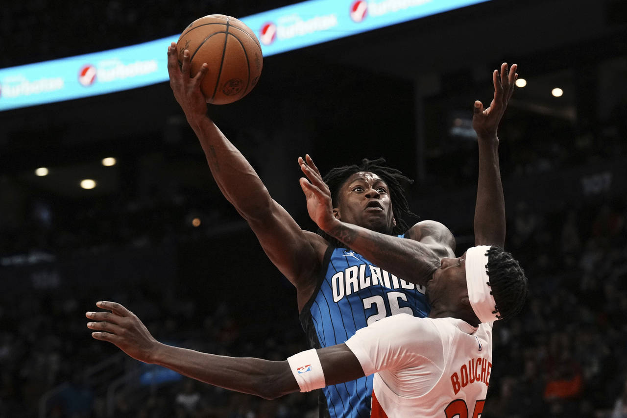 Toronto Raptors' Chris Boucher receives a blow to the mouth from Orlando Magic's Admiral Schofield'...