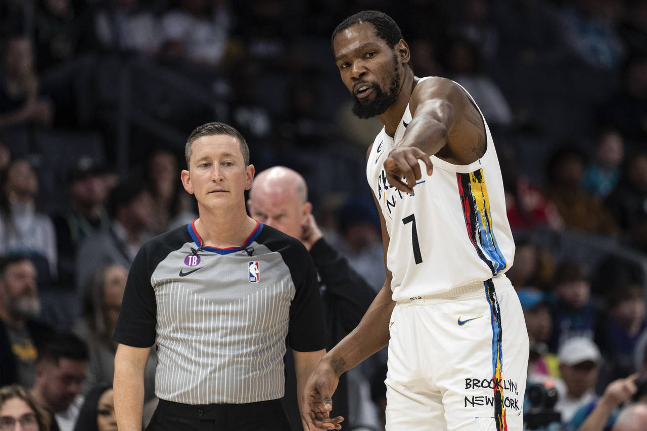 Referee Nick Buchert, left, listens to Brooklyn Nets forward Kevin Durant (7), during the first hal...