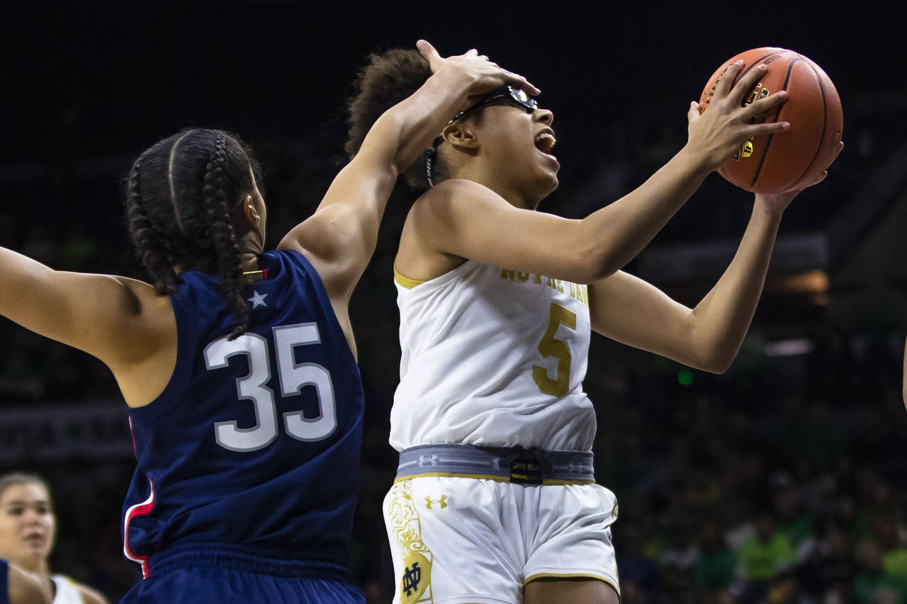 Notre Dame's Olivia Miles (5) tries to drive past Connecticut's Azzi Fudd (35) during the first hal...
