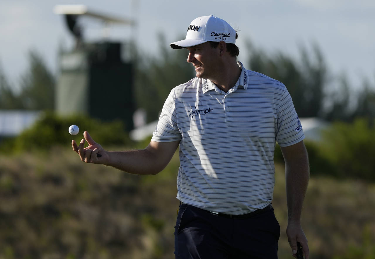 Sepp Straka, of Austria, tosses a ball to his caddie during the first round of the Hero World Chall...