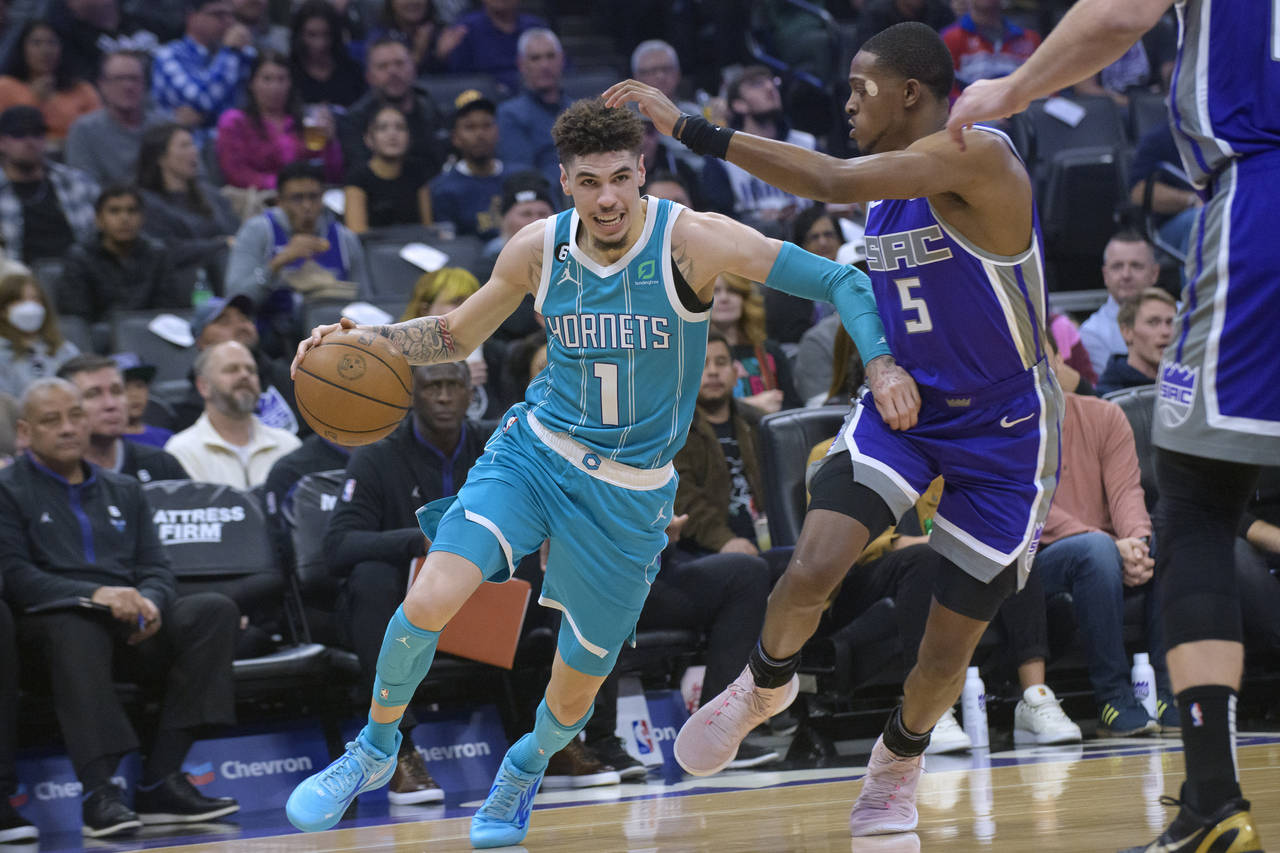 Charlotte Hornets guard LaMelo Ball (1) drives past Sacramento Kings guard De'Aaron Fox (5) during ...