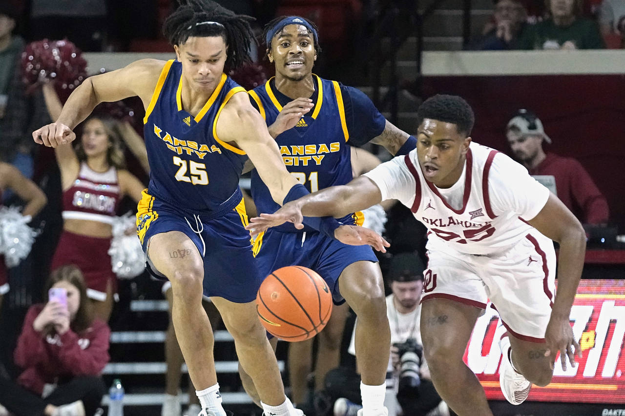 Kansas City guard Tyler Andrews (25) and Oklahoma guard Grant Sherfield, right, reach for the ball ...