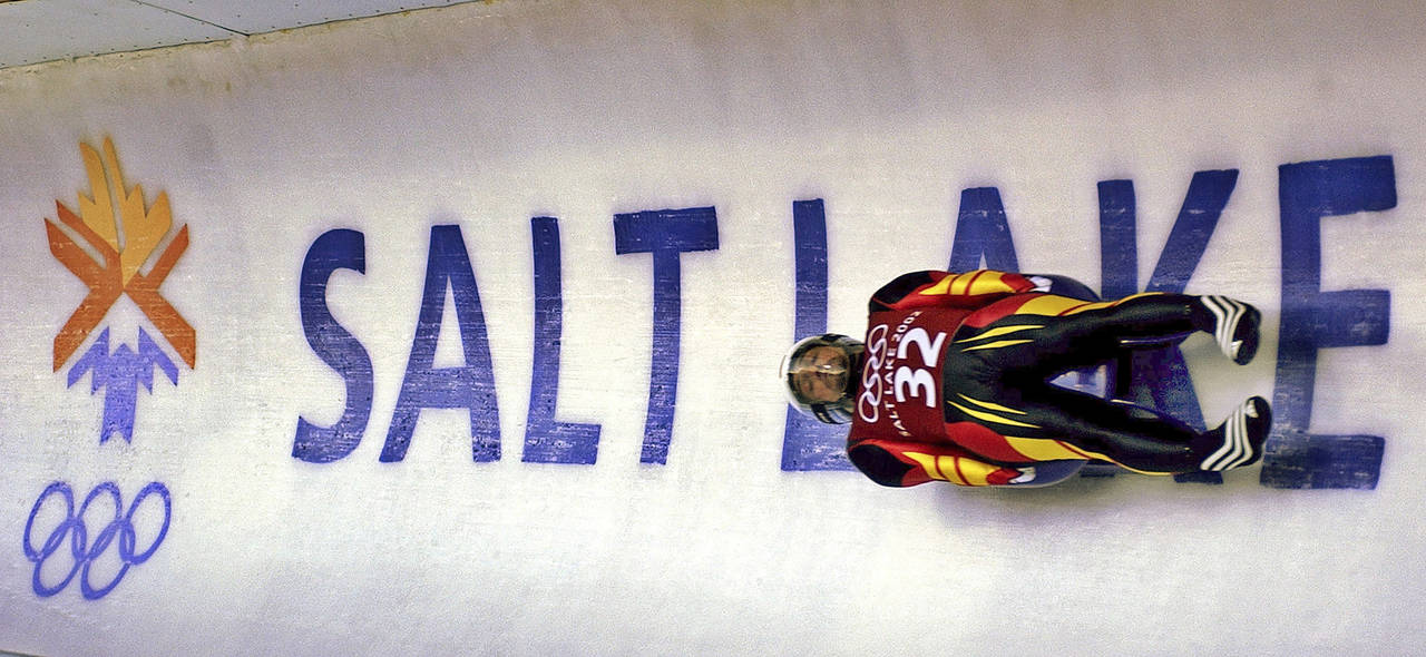 FILE - In this Feb. 9, 2002 ,file photo, Georg Hackl, of Germany, speeds past an Olympic logo durin...