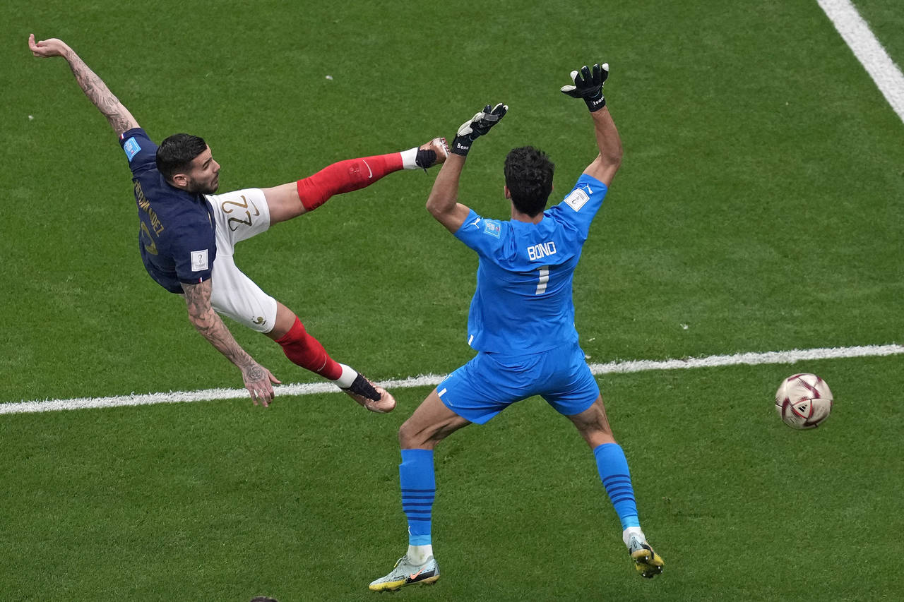 France's Theo Hernandez, left, shoots to score his side's opening goal during the World Cup semifin...