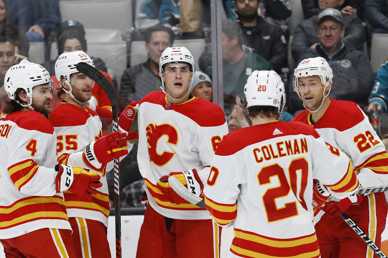 Calgary Flames center Trevor Lewis, right, celebrates with teammates after scoring a goal against t...